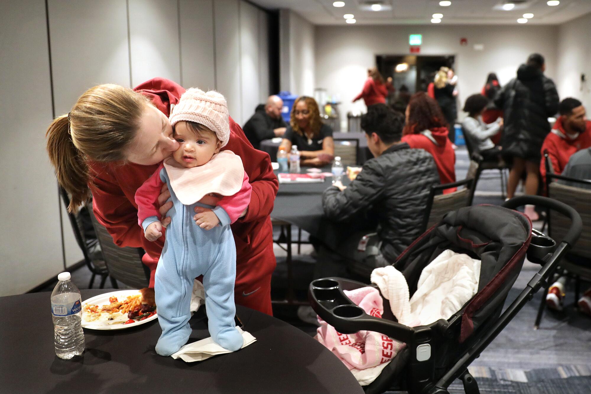 Lindsay Gottlieb kisses her daughter Reese during a team dinner while on the road in Boulder.