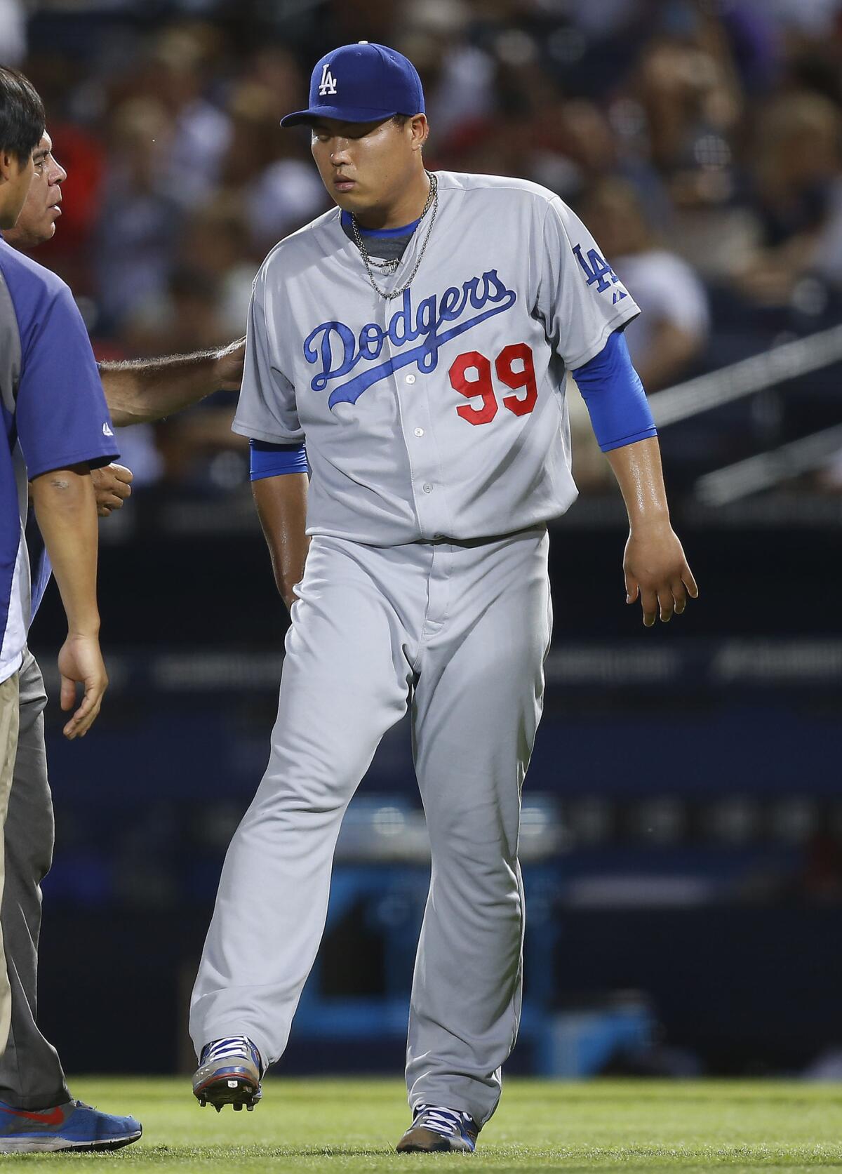 Dodgers pitcher Hyun-Jin Ryu holds his leg after straining a right buttock muscle Aug. 13 against the Braves.