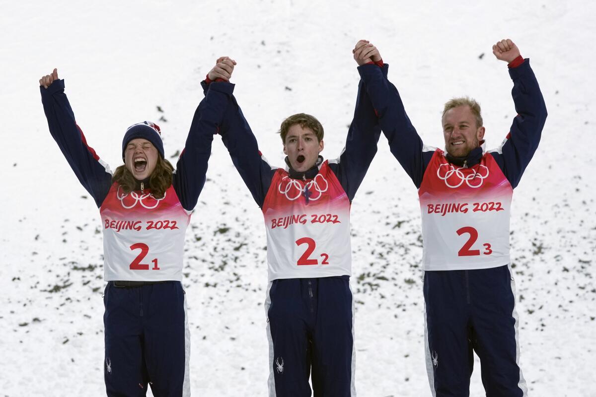 Ashley Caldwell, Christopher Lillis and Justin Schoenefeld of the U.S. join hands and lift their arms in celebration.