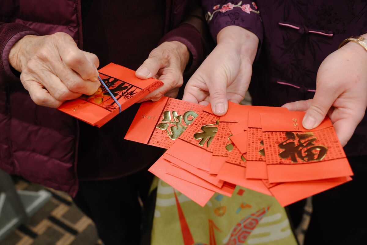 Taste of MP co-owner Lina Situ, right, distributes red envelopes to diners on Tuesday.