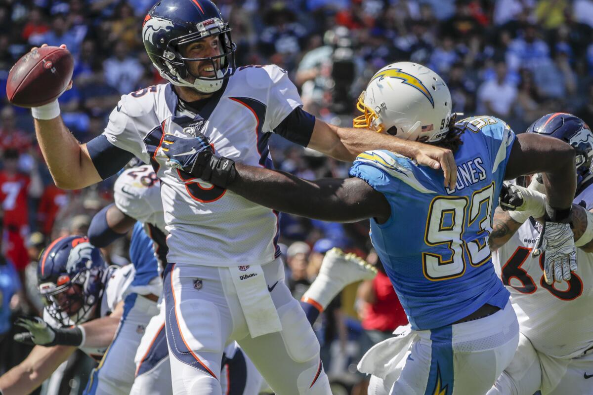 Broncos quarterback Joe Flacco tries to get off a pass while getting hit by Chargers defensive tackle Justin Jones on Sunday.