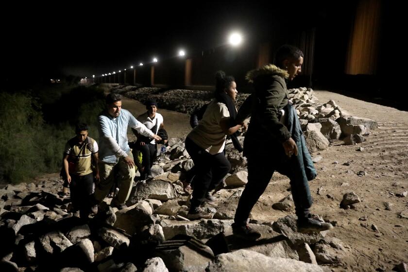 SOMERTON, AZ - MAY 11: Immigrants turn themselves over to U.S Border Patrol agents along the U.S.-Mexico border on Thursday, May 11, 2023 in Somerton, AZ. Title 42, a pandemic-era policy that allowed border agents to quickly turn back migrants, expires this week. Under a new rule, the U.S. on Thursday will begin denying asylum to migrants who show up at the U.S.-Mexico border without first applying online or seeking protection in a country they passed through. (Gary Coronado / Los Angeles Times)