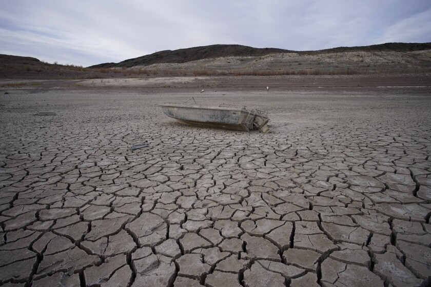 A boat sits on cracked earth hundreds of feet from the shoreline of Lake Mead near Boulder City, Nev. 