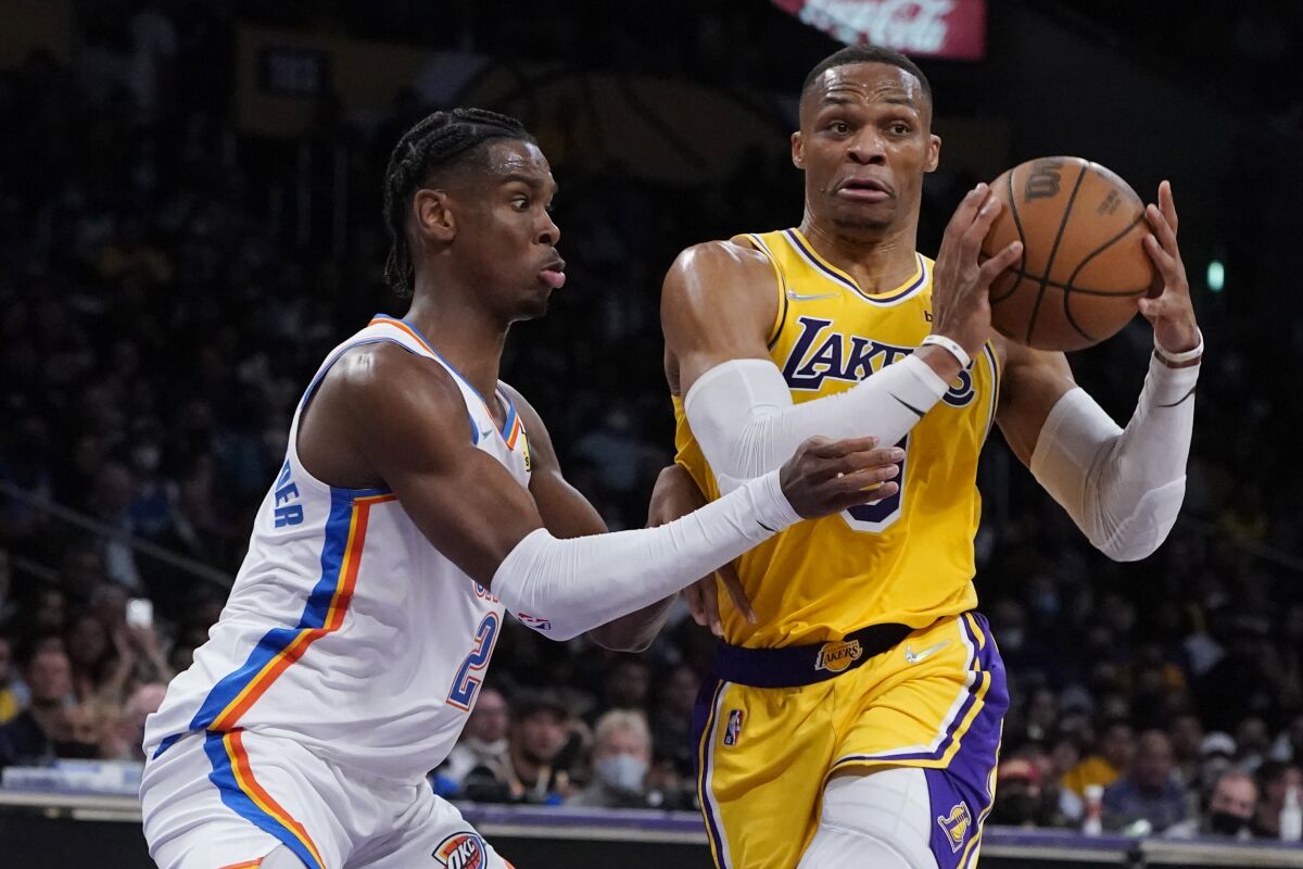 Los Angeles Lakers guard Russell Westbrook, right, is defended by Oklahoma City Thunder guard Shai Gilgeous-Alexander during the first half of an NBA basketball game Thursday, Nov. 4, 2021, in Los Angeles. (AP Photo/Marcio Jose Sanchez)