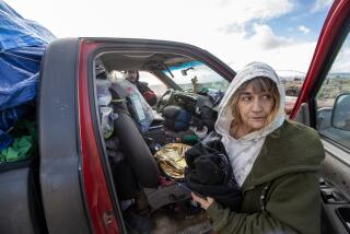 LANCASTER, CA - FEBRUARY 23: Crystal Jones, 63, right, and Tony Chavez, 59, left, pack up their truck at a homeless camp where Los Angeles County Homeless Services Authority outreach workers are enrolling them in an emergency shelter program ahead of a brutal winter storm on Thursday, Feb. 23, 2023 in Lancaster, CA. (Brian van der Brug / Los Angeles Times)