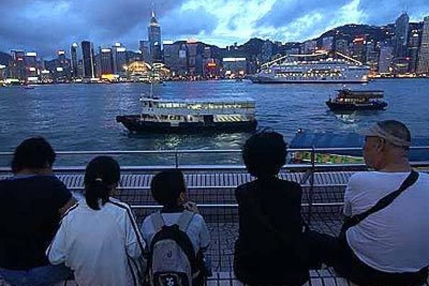 From the promenade of the Hong Kong Cultural Center on the Kowloon Peninsula, visitors gaze across the harbor to the skyline of Hong Kong Island.