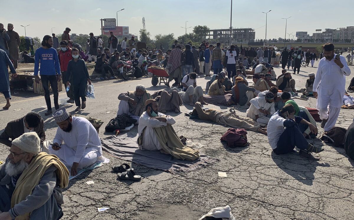 Supporters of 'Tehreek-e-Labaik Pakistan, a religious political party, take a rest while blocking a main road during an anti-France rally in Islamabad, Pakistan, Monday, Nov. 16, 2020. The supporters are protesting the French President Emmanuel Macron over his recent statements and the republishing in France of caricatures of the Muslim Prophet Muhammad they deem blasphemous. (AP Photo/Anjum Naveed)