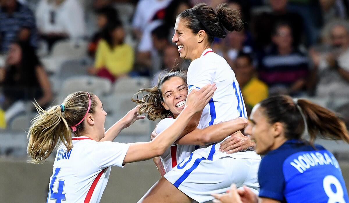 Carli Lloyd jumps into the arms of U.S. teammate Heath Tobin after scoring a goal against France during the 2016 Rio Olympics.