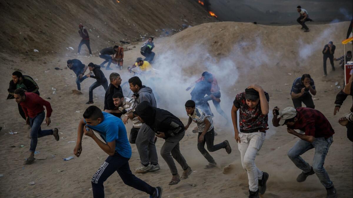 Protesters scatter from tear gas during a border protest in Bureij, Gaza.