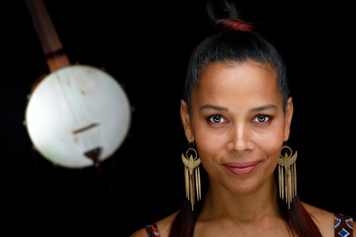Rhiannon Giddens is shown in close up, wearing a pair of large earrings in the form of birds.