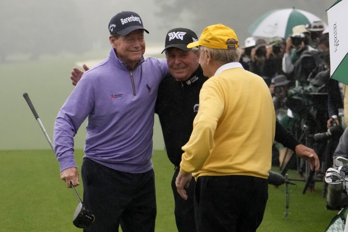 Tom Watson, left, Gary Player, and Jack Nicklaus, right, hug during the honorary starter ceremony before the first round at the Masters golf tournament on Thursday, April 7, 2022, in Augusta, Ga. (AP Photo/Charlie Riedel)