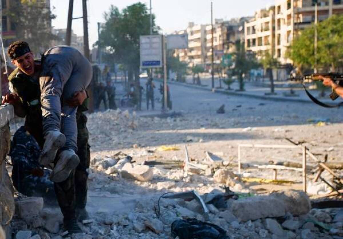 A Syrian rebel carries the body of his brother, killed during a battle in Syria's northern city of Aleppo.
