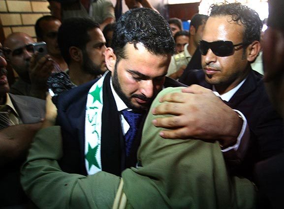 Muntather Zaidi, the Iraqi television reporter jailed for throwing his shoes at former President George W. Bush, hugs his sister following his release after a nine-month stint in prison.