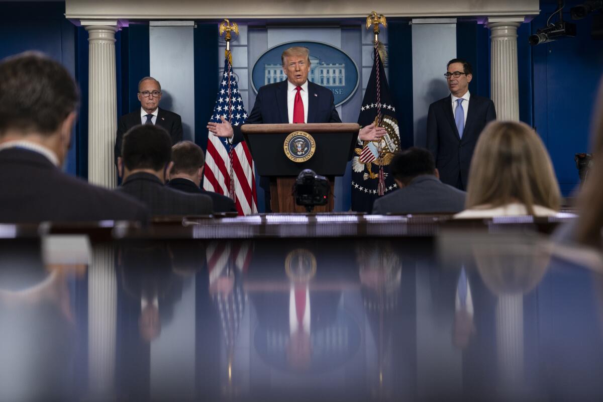 President Trump speaks at a July 2 White House news briefing, with Larry Kudlow, left, and Steven Mnuchin.