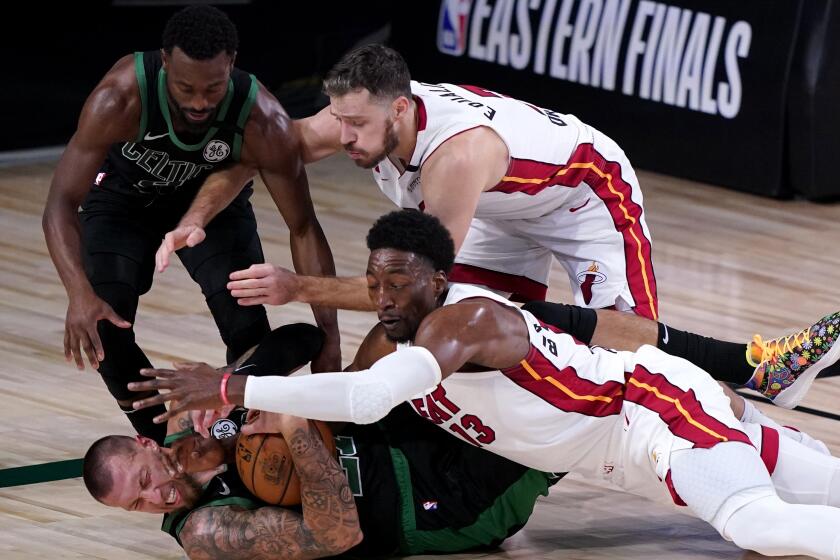 Boston Celtics' Kemba Walker, top left, and center Daniel Theis, bottom left, attempt to gain control of a loose ball.