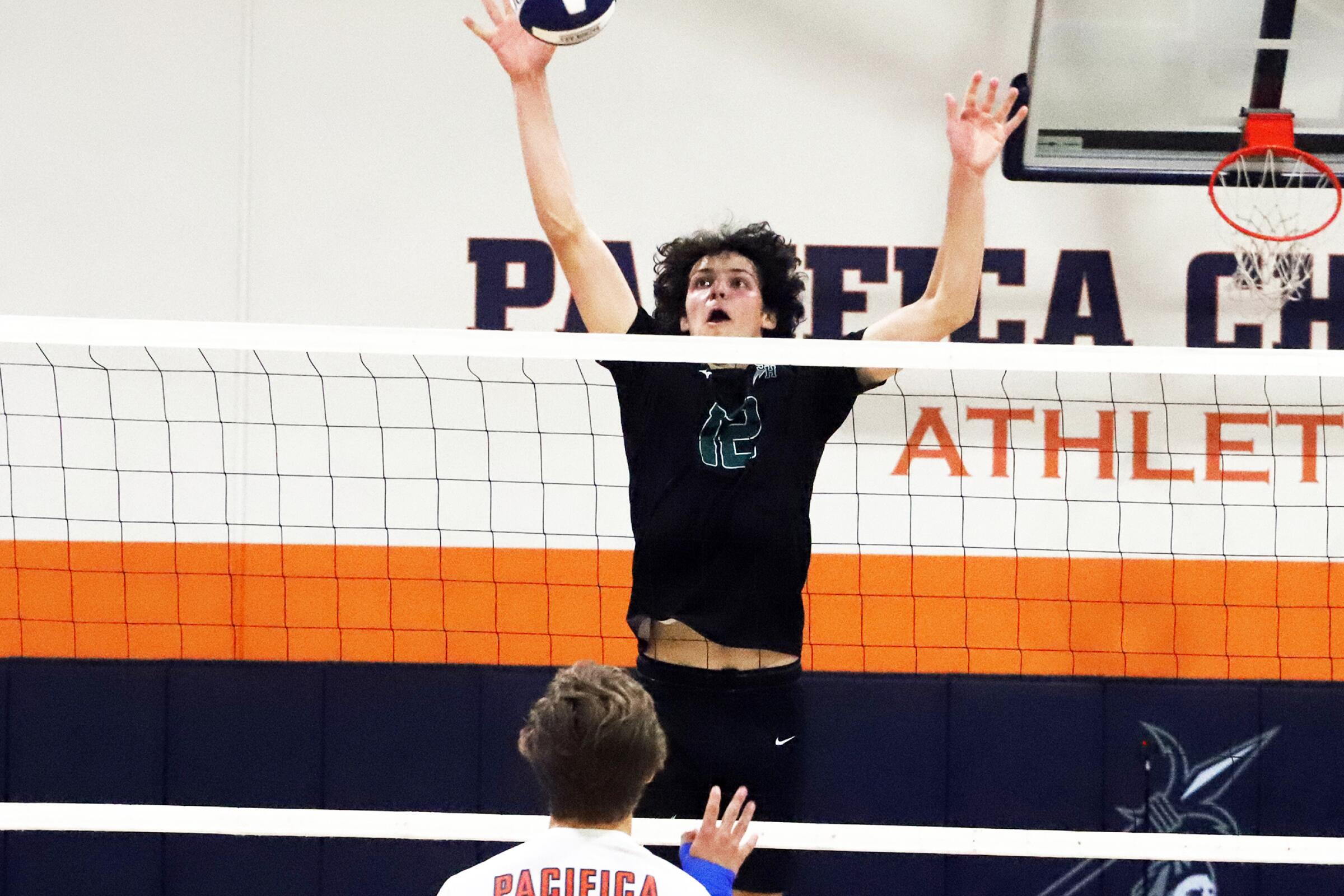 Sage Hill's Jackson Cryst (12) blocks the ball and makes a return during Sage Hill High School boys' volleyball team against Pacifica Christian High School boys' volleyball team in a nonleague volleyball match at Pacifica Christian High School in Newport Beach on Friday, April 19, 2024. (Photo by James Carbone)