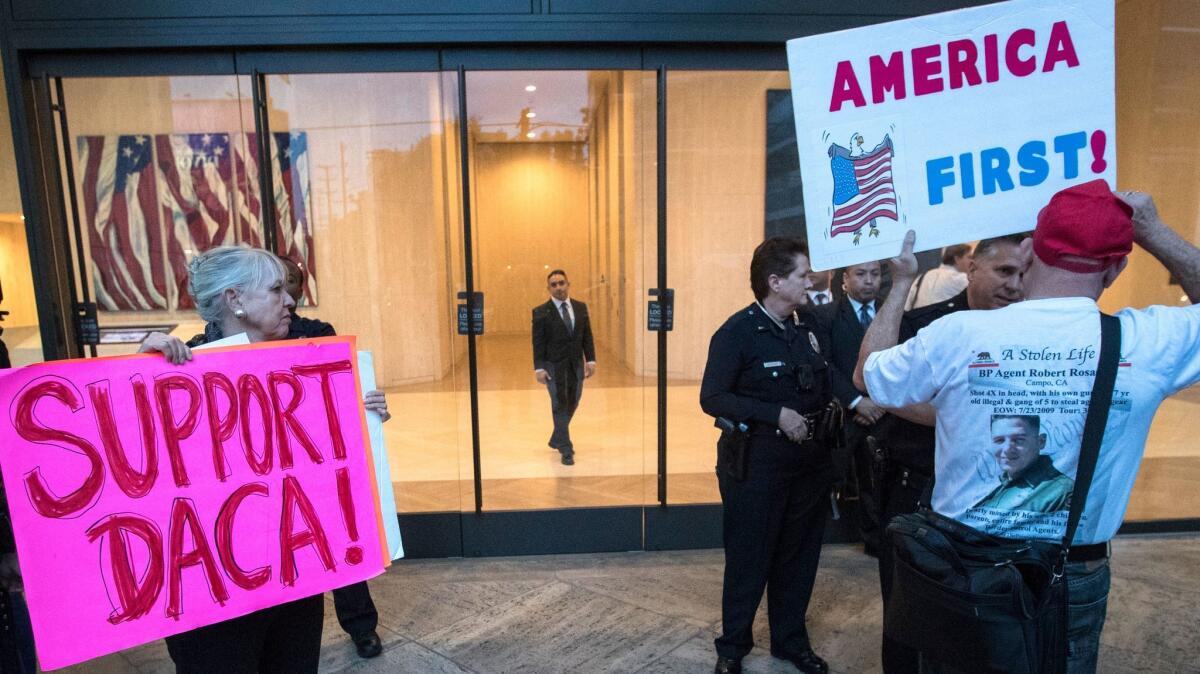 DACA supporter Michele Modglin, left, waits outside with counter-demonstrators at Sen. Diane Feinstein's L.A. offices to show support for "Dreamers."