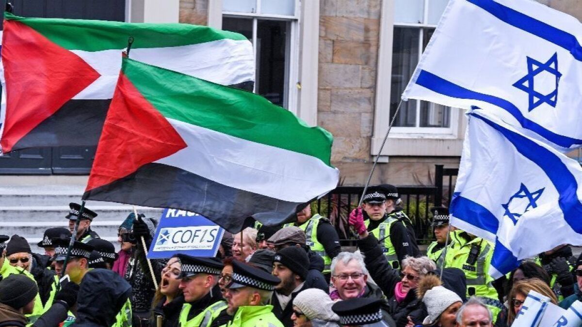 Palestinian and Israeli flags fly as rival protesters face off.