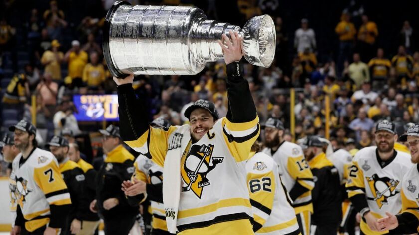 Pittsburgh Penguins captain Sidney Crosby carries the Stanley Cup after the Penguins defeated the Nashville Predators in Game 6 of the Stanley Cup Final, Sunday.
