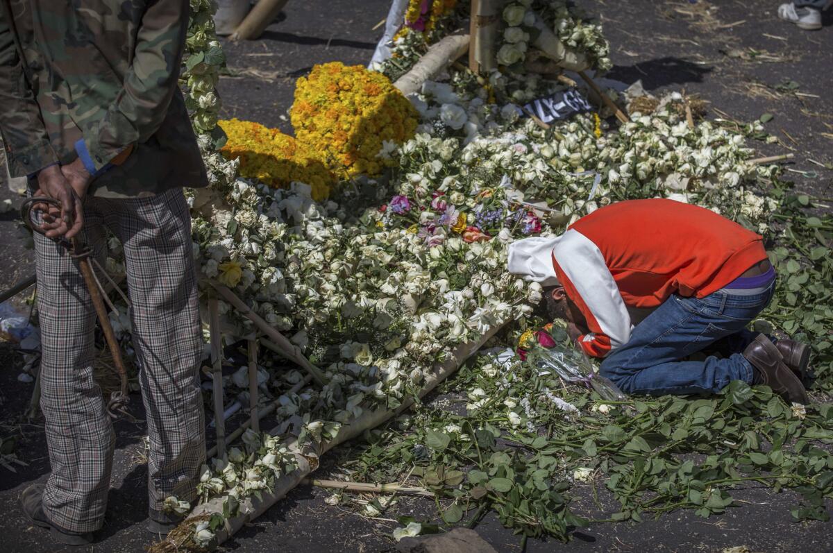 El familiar de una de las vícitmas del accidente de un avión de Ethiopian Airlines llora a su ser querido sobre un arreglo floral en el lugar del choque, cerca de Bishoftu, sur-este de Adís Abeba, en Etiopía.