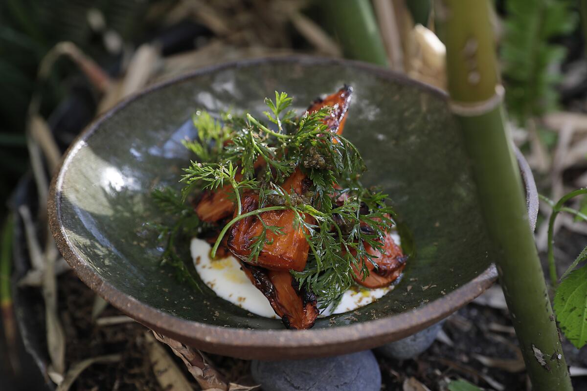 Grilled carrots, roasted poblanos, citrus-spice vinaigrette, black lime and carrot tops, on the patio at the Hearth & Hound.