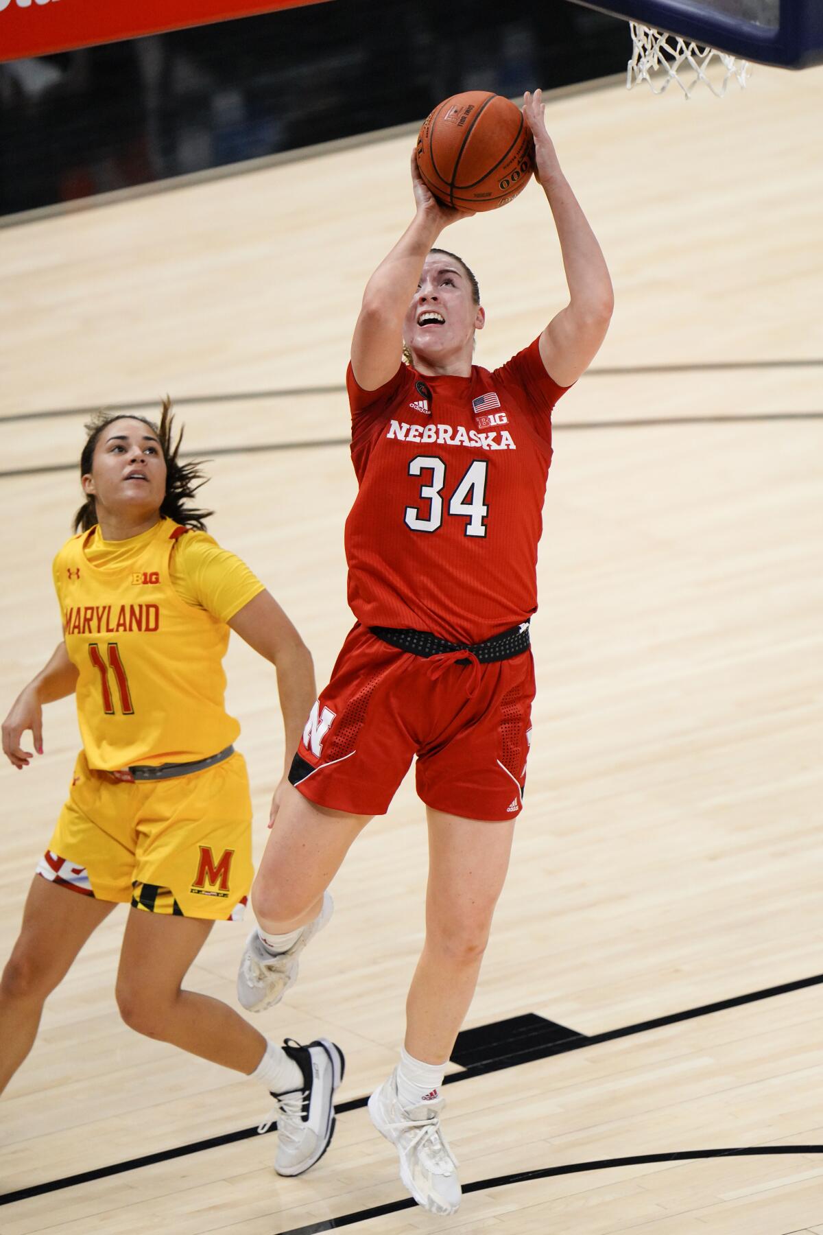 Nebraska forward Isabelle Bourne (34) shoots in front of Maryland guard Katie Benzan (11) in the second half of an NCAA college basketball game in the quarterfinals of the Big Ten Conference tournament in Indianapolis, Thursday, March 11, 2021. Maryland won 83-73. (AP Photo/AJ Mast)