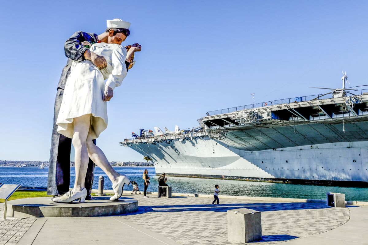 Sculpture on display of a sailor kissing a nurse on the dock next to the USS Midway
