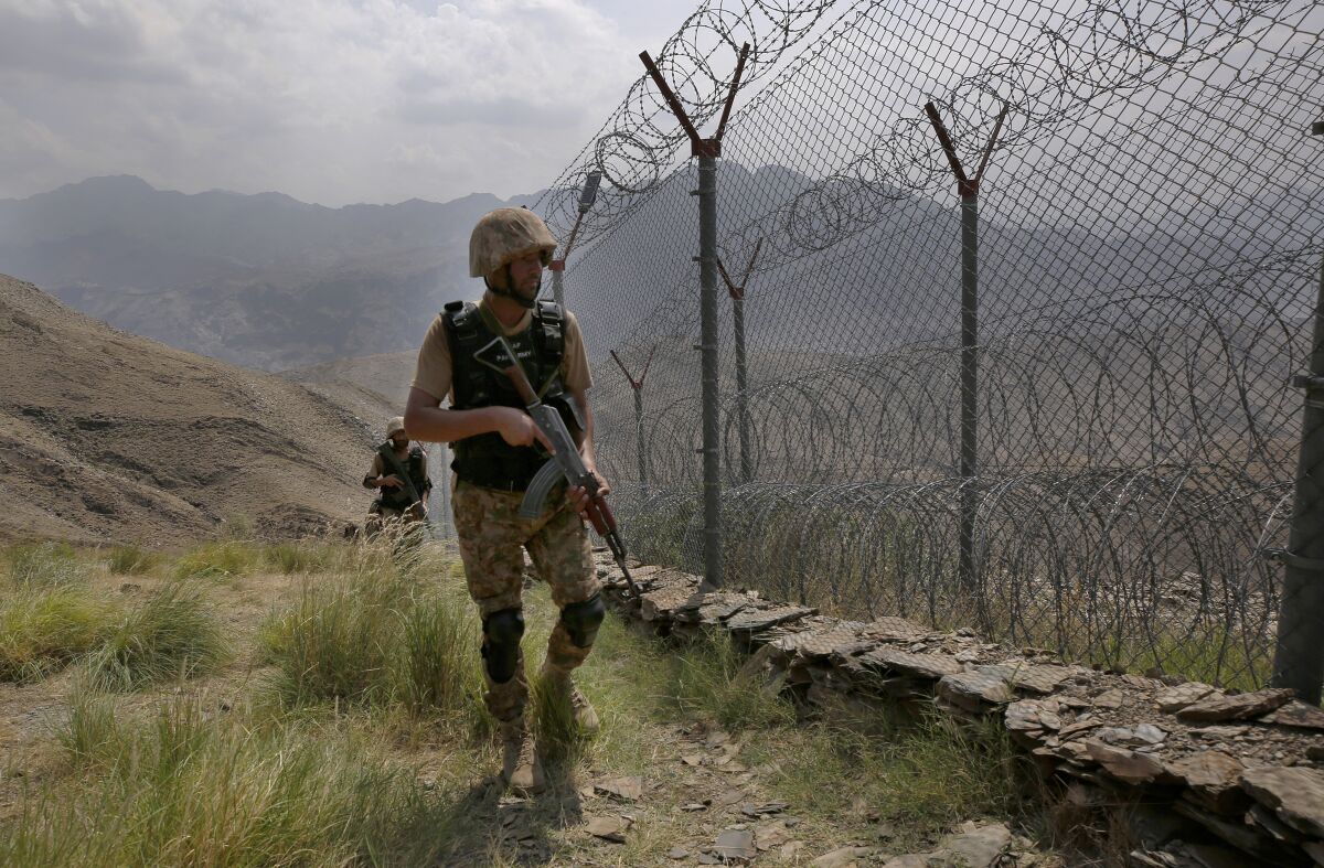 FILE - In this Aug. 3, 2021 file photo, Pakistan Army troops patrol along the fence on the Pakistan Afghanistan border at Big Ben hilltop post in Khyber district, Pakistan. The Taliban win in Afghanistan is giving a boost to militants in neighboring Pakistan. The Pakistani Taliban, known as the TTP, have become emboldened in tribal areas along the border with Afghanistan. (AP Photo/Anjum Naveed, File)