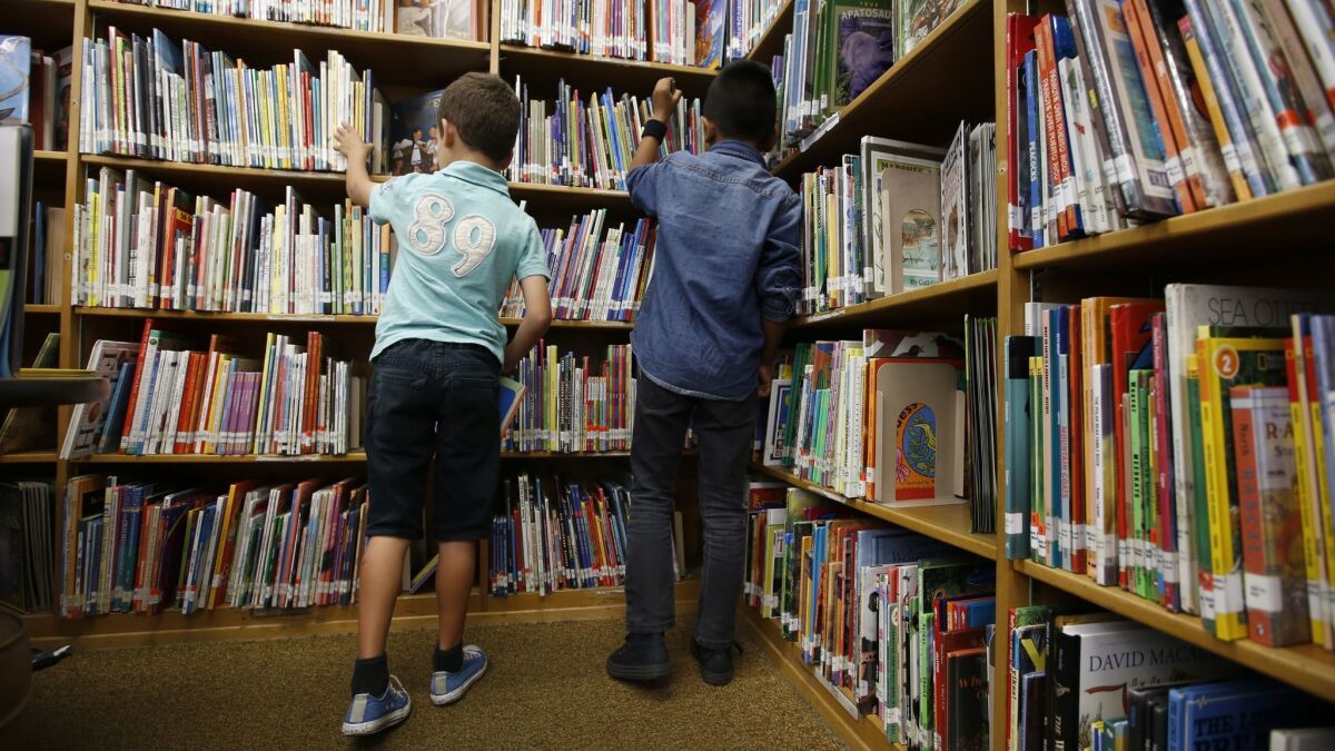 Second-graders look for books in the library at Meyler Street Elementary School in Torrance in 2017. L.A. Unified elementary school libraries are on the chopping block once again.