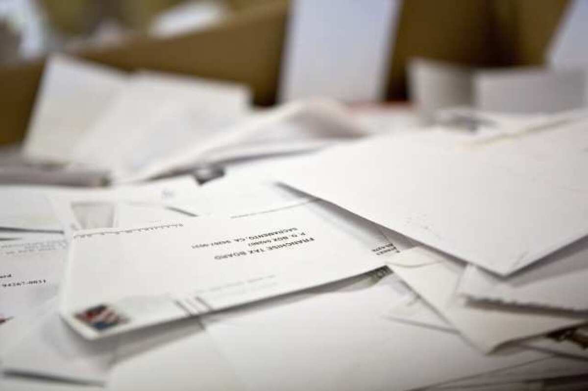 Cajas grandes llenas de sobres ya abiertos y vacíos en el Franchise Tax Board antes de ser reciclados en Sacramento.
