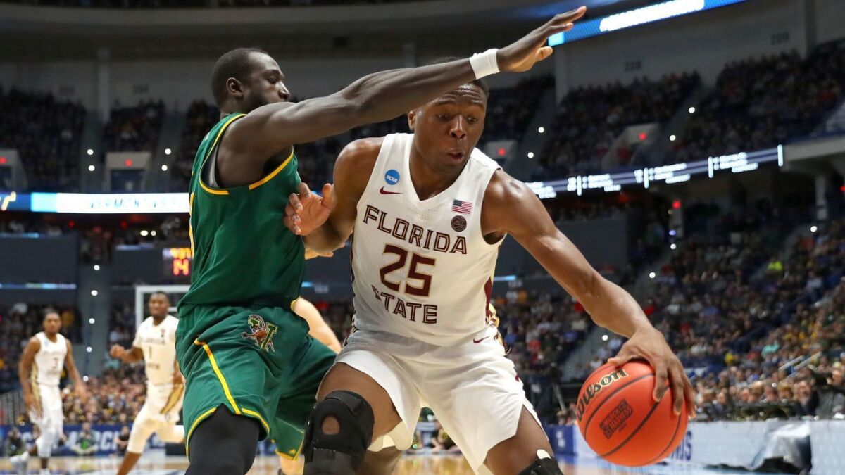 Florida State's Mfiondu Kabengele is defended by Vermont's Samuel Dingba.