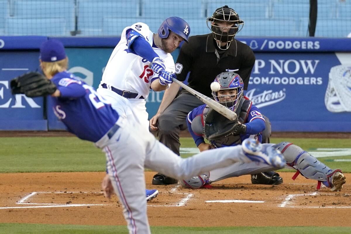 Los Angeles Dodgers' Max Muncy, second from left, hits a solo home run as Texas Rangers starting pitcher Mike Foltynewicz.