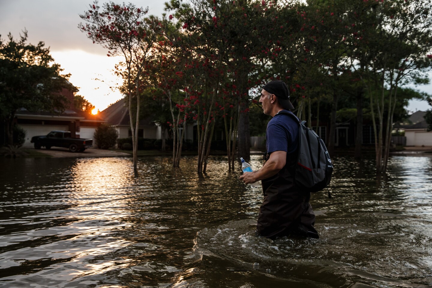 Samir Novruzov wades through water to get to a vehicle after spending the day clearing out his flooded home in Katy, Texas.