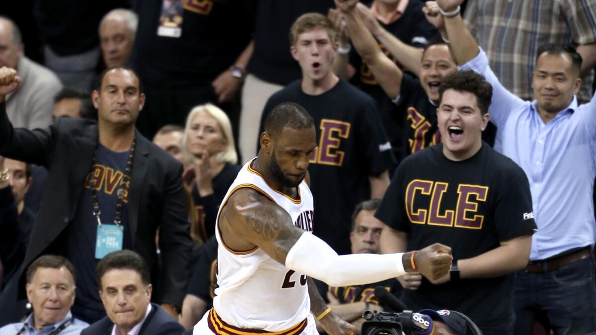 Cavaliers forward LeBron James celebrates, along with fans, after scoring against the Warriors in the second half of Game 6 on Thursday night.
