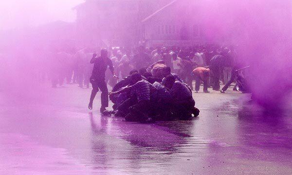 Police use colored water from a water cannon to disperse teachers protesting for better wages in Srinagar, India.