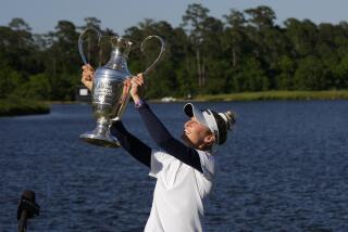 Nelly Korda holds up the trophy while celebrating her win at the Chevron Championship.