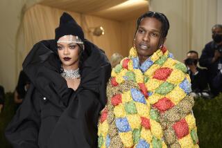 Rihanna poses in a puffy black dress next to ASAP Rocky posing in a rainbow quilt.