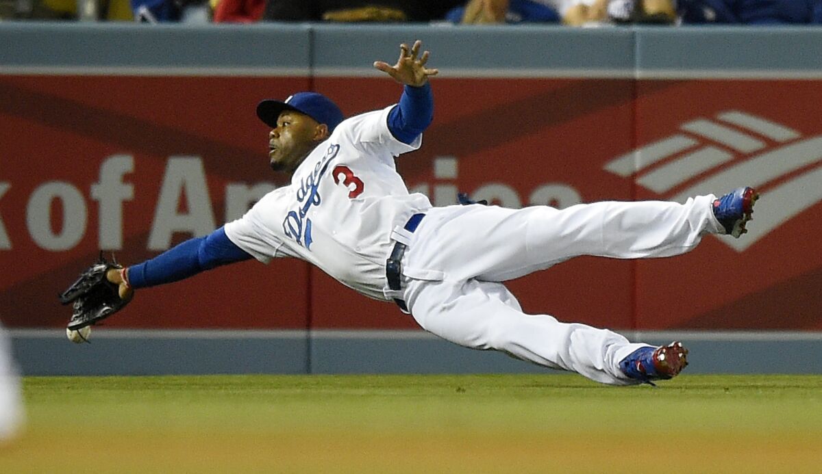 Dodgers left fielder Carl Crawford can't make a diving catch on a double hit by Philadelphia's Chase Utley during Monday's loss. Crawford also was involved in a fielding mishap Tuesday that played a big role in another loss to the Phillies.