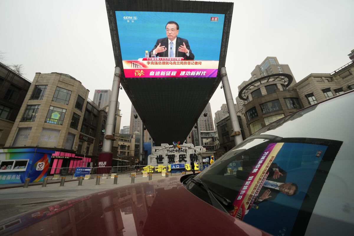 A large video screen at a shopping mall shows Chinese Premier Li Keqiang as he speaks during a press conference after the closing session of China's National People's Congress (NPC) in Beijing, Friday, March 11, 2022. (AP Photo/Ng Han Guan)