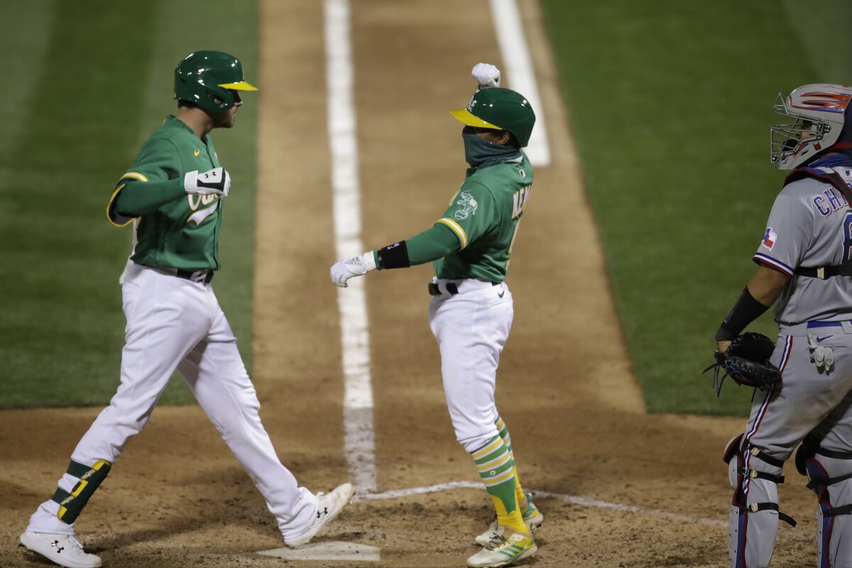 Oakland Athletics' Austin Allen, left, celebrates with Tony Kemp after hitting a two run home run off Texas Rangers' Ian Gibaut in the seventh inning of a baseball game Wednesday, Aug. 5, 2020, in Oakland, Calif. (AP Photo/Ben Margot)