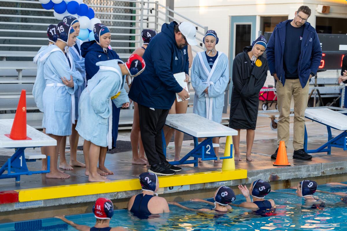 CdM head coach Marc Hunt, center, draws up a play for the team during Saturday's match.
