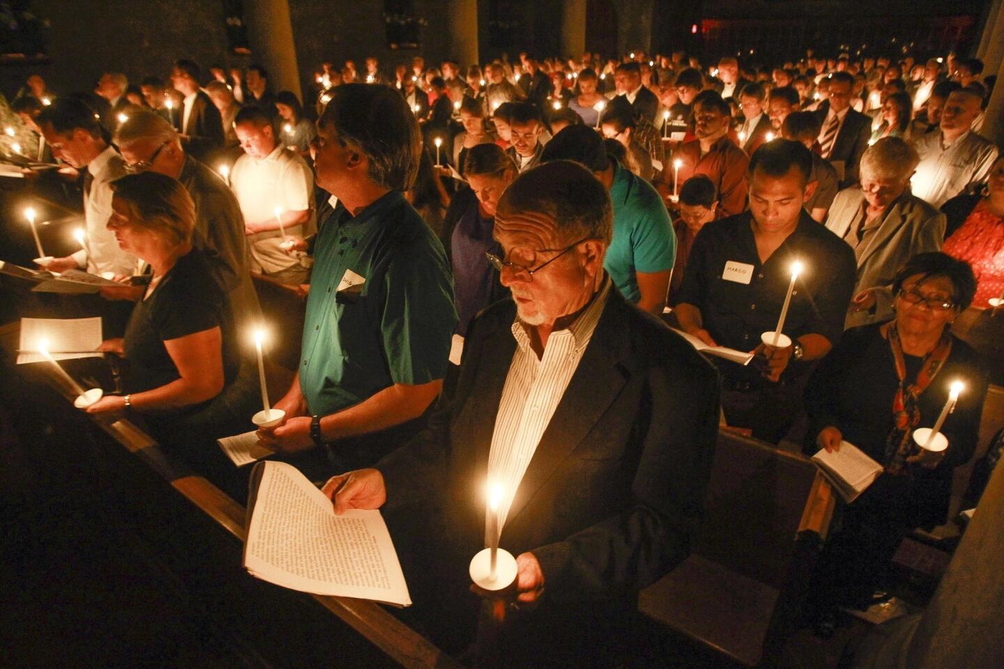 Parishioners hold lit candles during The Vigil of Easter at St. Paul's Cathedral.