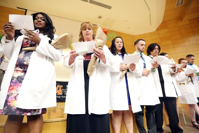 Graduating nursing students recite the Nightingale Pledge during a ceremony on May 8.