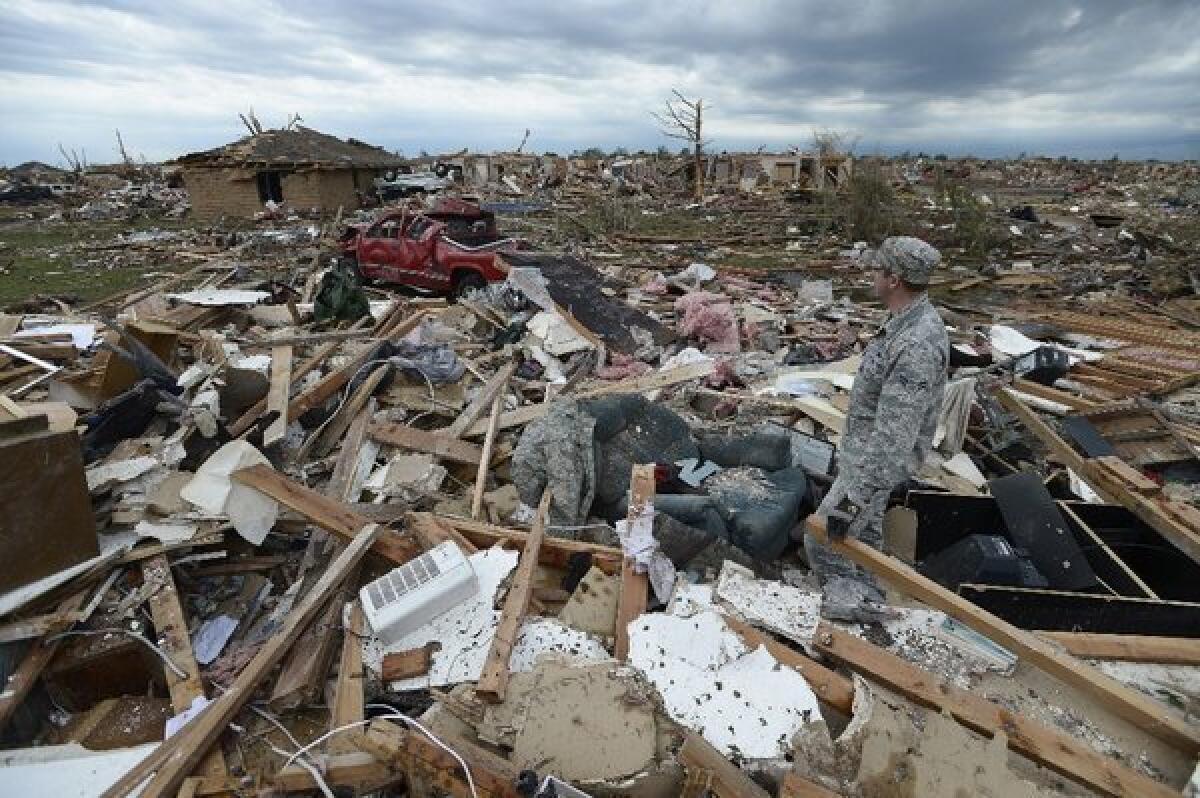 A resident of Moore, Okla., surveys damage left behind by the devastating tornado that passed through on Monday. It was the third megatornado to strike there since 1999.