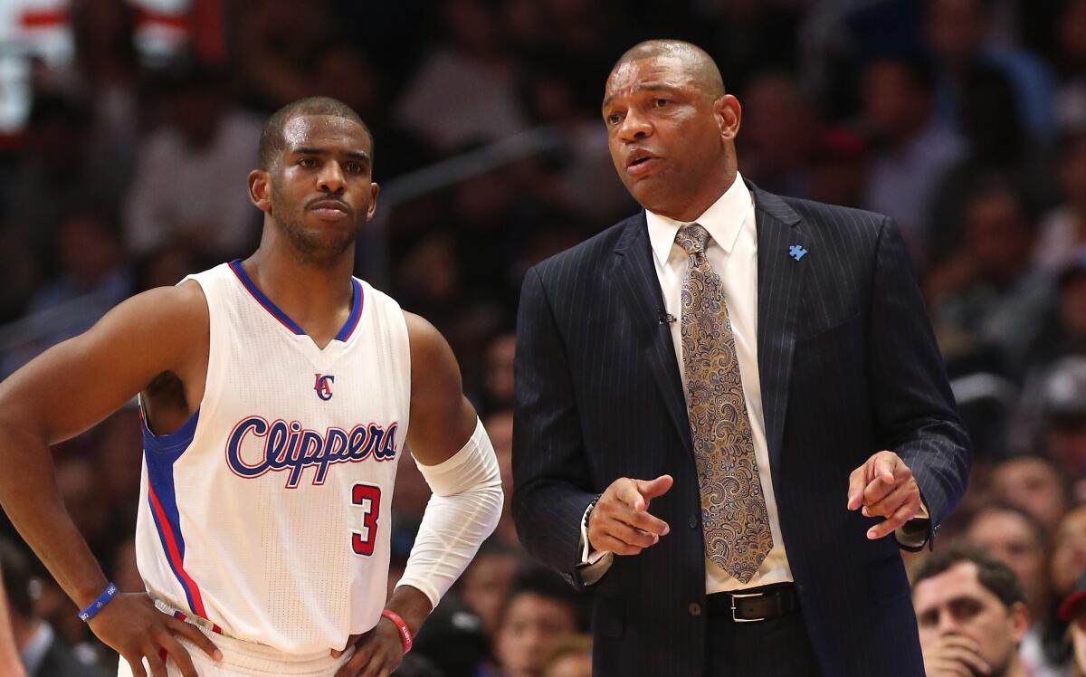 Clippers coach Doc Rivers talks to point guard Chris Paul on the court during the 2015 NBA season.