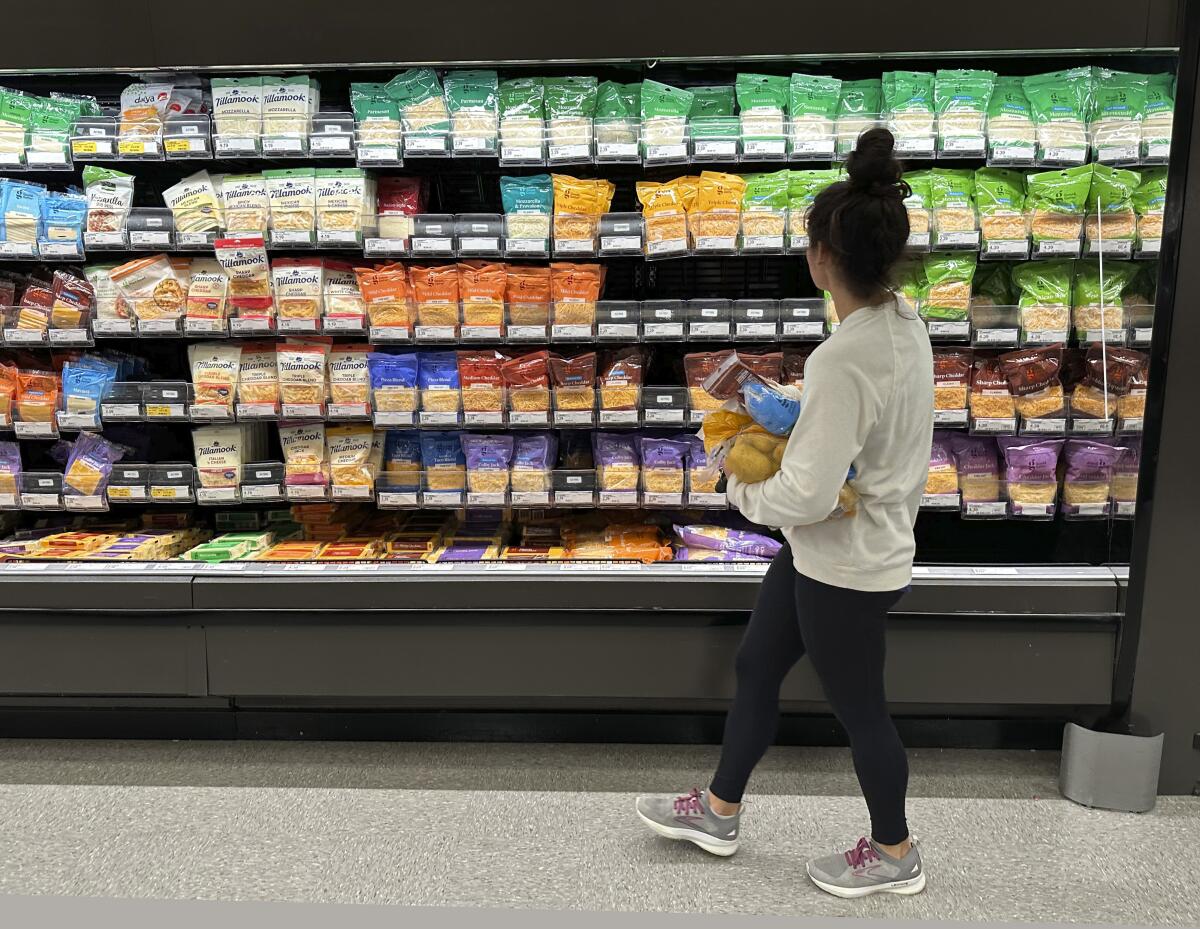 A shopper looks at cheese aisle
