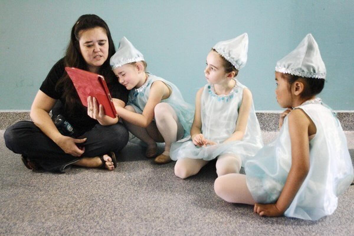 Michele Ferren, from left, reads "Junie B. Jones and Some Sneaky Pesky Spying" to her daughter, Madison, 6, Isla Welsh, 6, and Sydney Chan, 6, during rehearsal for an upcoming performance, "Thumbelina," which took place at the California Contemporary Ballet dance studio in La Canada on Saturday, June 22, 2013.