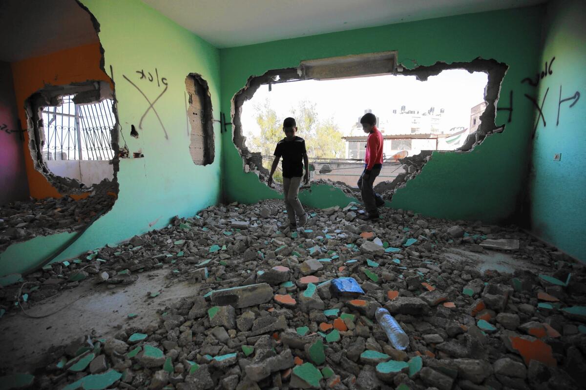 Palestinians inspect the damage at the apartment of a Palestinian assailant who in January stabbed an Israeli woman to death. The unit in the Qalandia refugee camp in the West Bank was partially destroyed by Israeli forces in April.