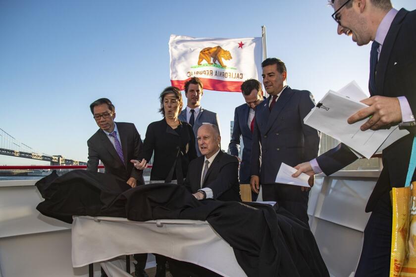 SAN FRANCISCO, CA - SEPTEMBER 13, 2018: The wind kicks up as Gov. Jerry Brown prepares to sign many climate bills with dignitaries behind him aboard a ferry cruising the San Francisco Bay at the end of the first full day of the Global Climate Action Summit on September 13, 2018 in San Francisco, California. (Gina Ferazzi/Los AngelesTimes)