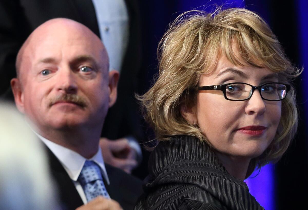 Gabrielle Giffords and Mark Kelly, seen in May 2013, are writing a book about gun control.